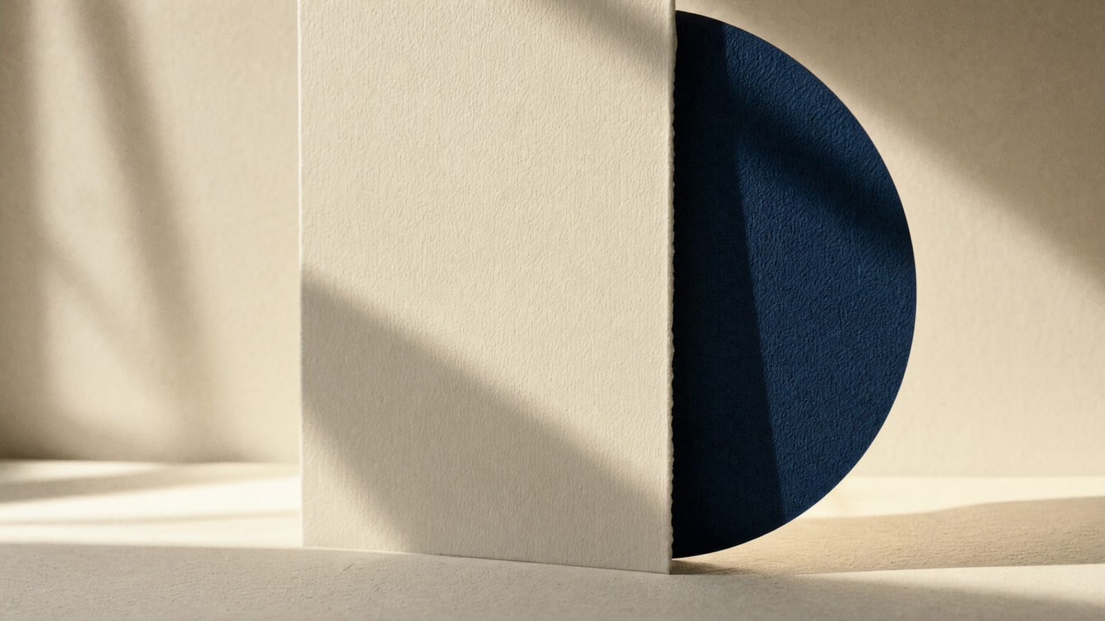 A cream paper panel and a midnight navy disc, an abstract for what an AI operator does