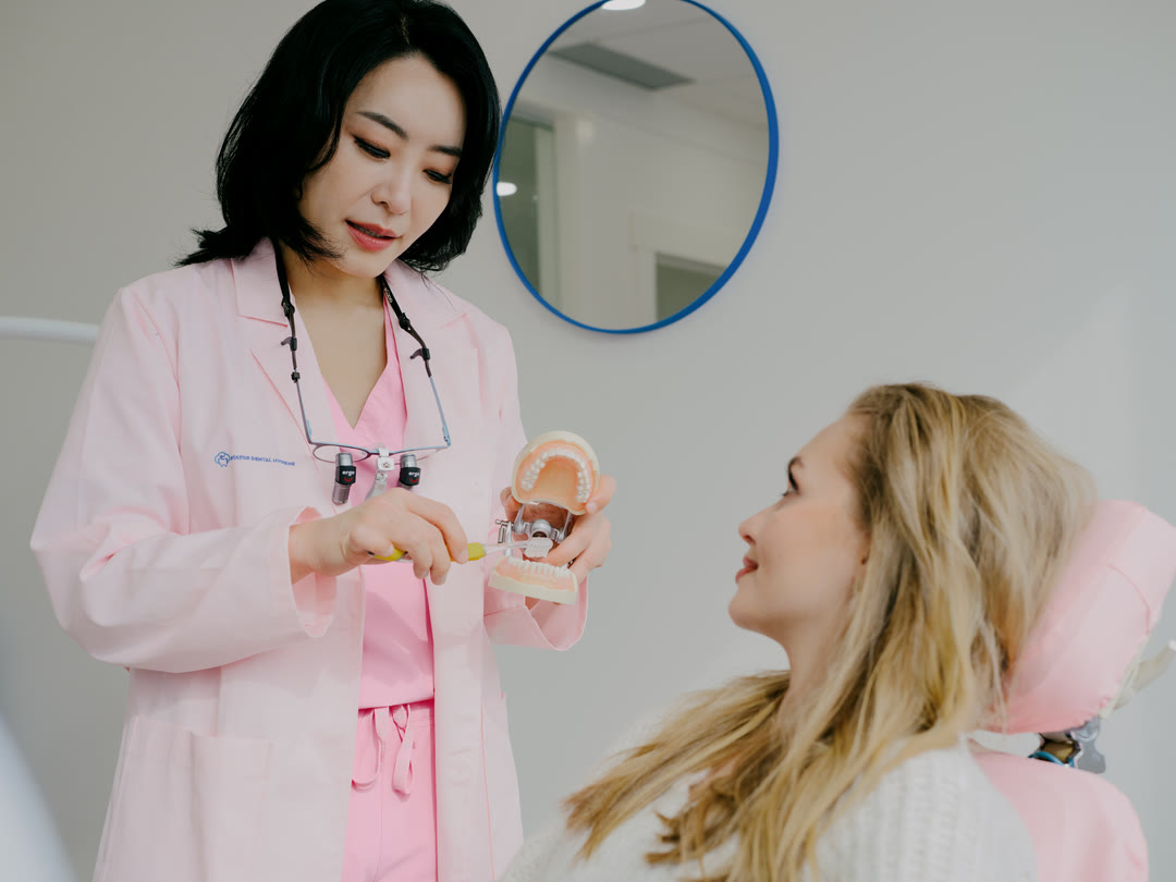 The Aviator Dental Hygiene owner walking a patient through brushing technique on a dental model